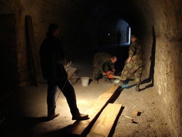 Dřevěné fošny se upravují na potřebnou míru přímo v podzemí pevnosti.