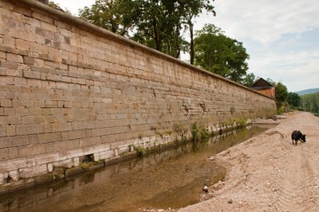 V řečišti byla vytvořena „cesta“ po které se pohybuje technika zajišťující opravy zdí.