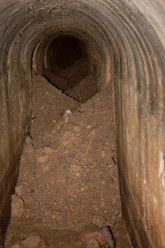 Smutný pohled na vysypané výklenky v hluboké minové chodbě.