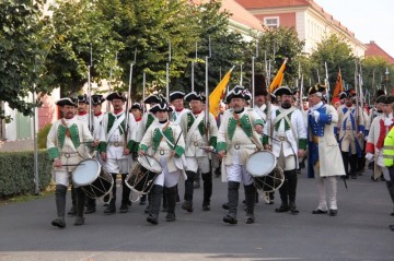 Od kostela pochodují vojáci městem k základnímu kameni pevnosti Terezín.