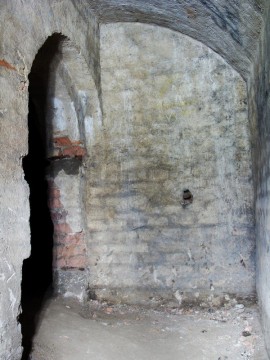 I zde nacházíme známky po vytrhaných pantech dveří. Zde se však ve stěně zachovala část zajištění vrat.